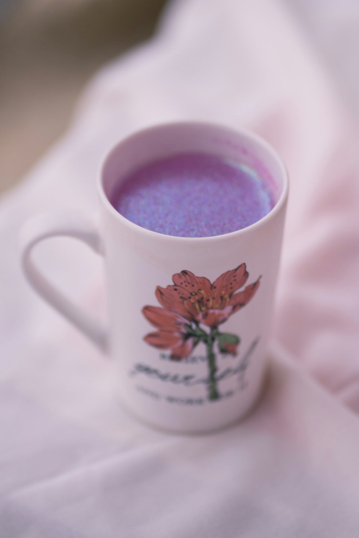 a cup of tea sitting on top of a bed