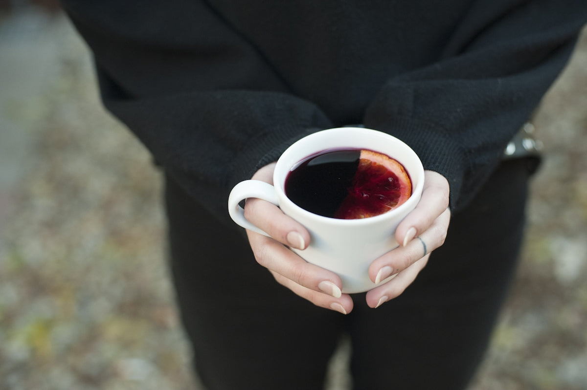 Hands holding a mug of mulled wine.