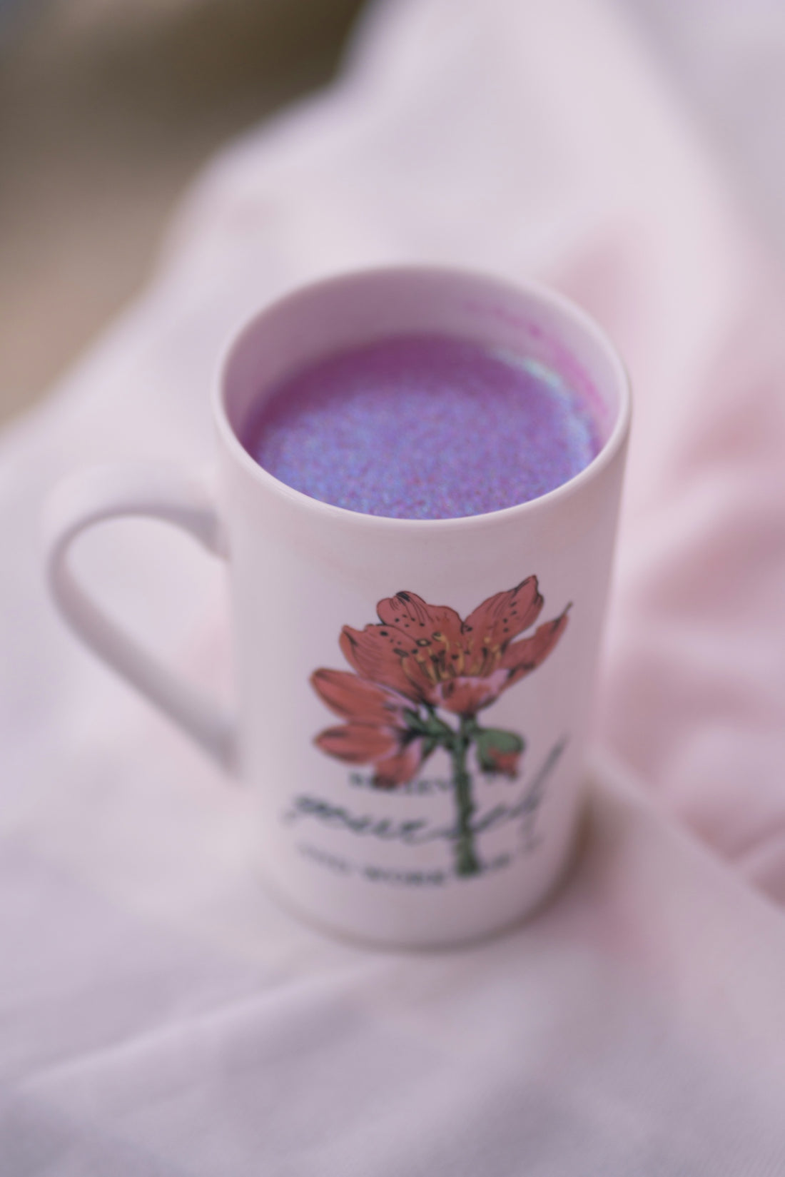 a cup of tea sitting on top of a bed