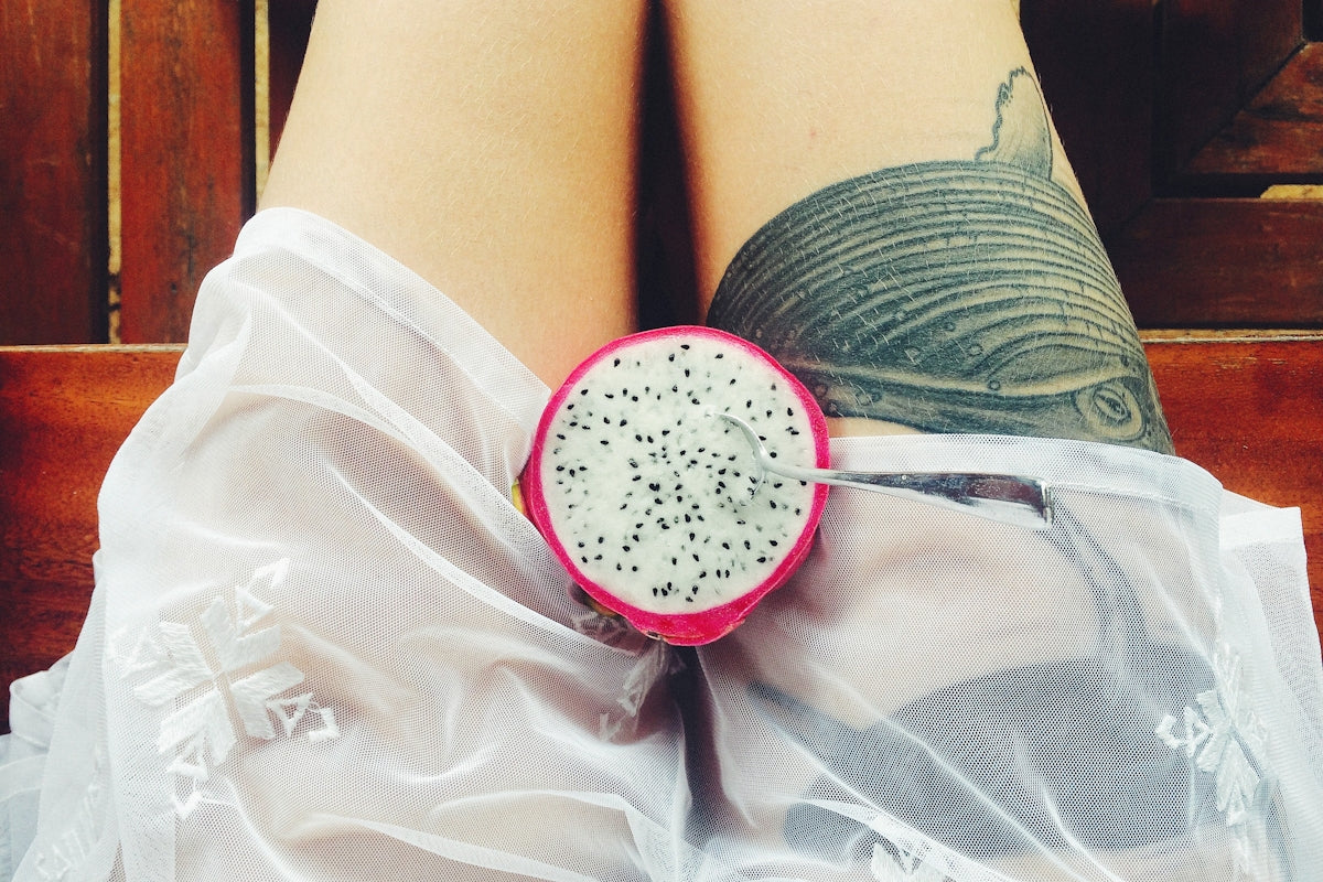 a close up of a person's legs with a piece of fruit on top