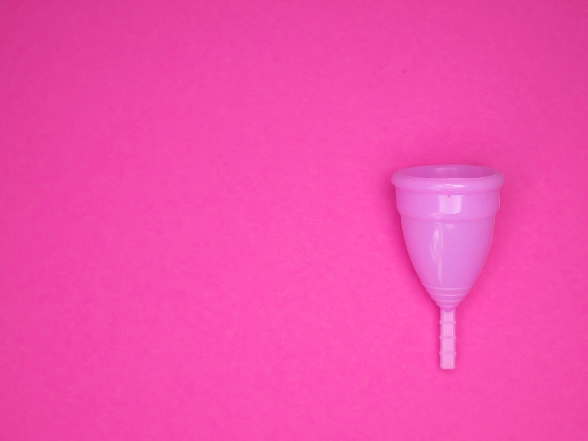 a pink plastic cup sitting on top of a pink surface