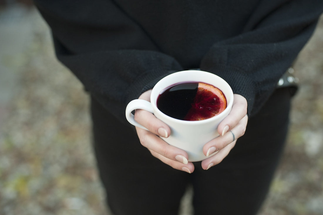 Hands holding a mug of mulled wine.