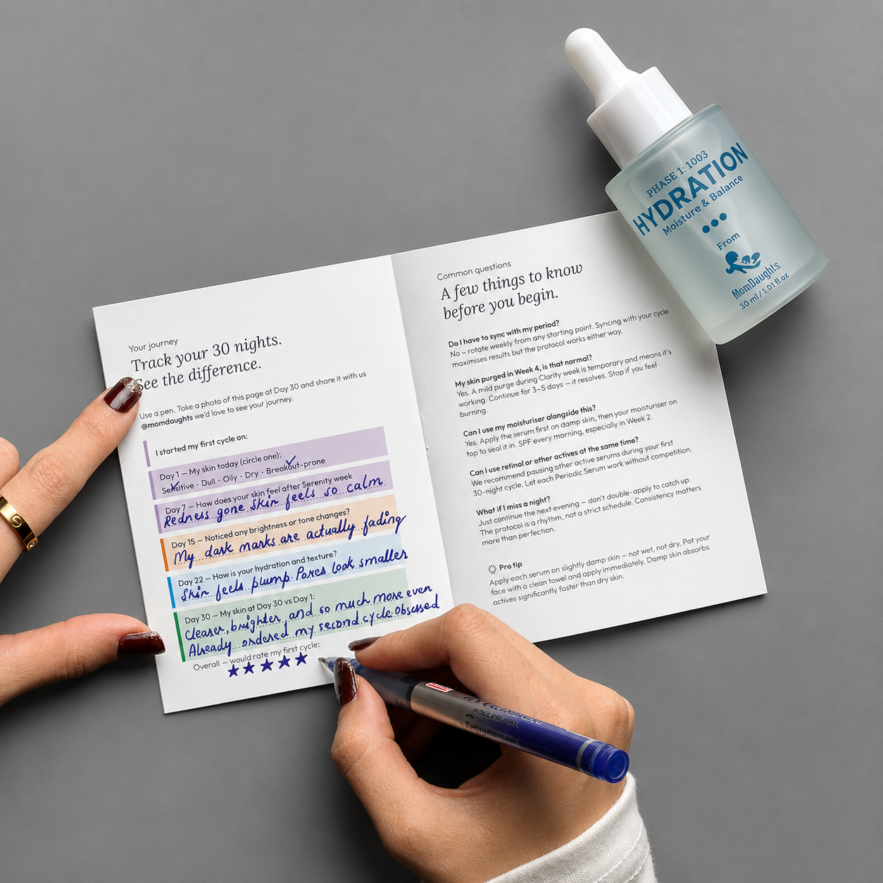 Person using a pen to write on a brochure with a bottle of skincare product labeled 'Hydration' on a gray background.